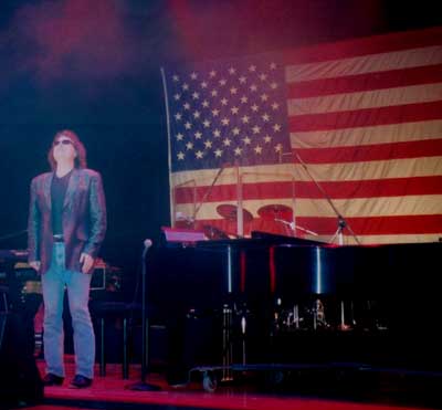 Ronnie, standing in front of American Flag at end of show